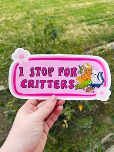 someone holding up a pink sticker that says i stop for critters