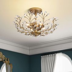 a chandelier hanging from the ceiling in a room with blue walls and curtains