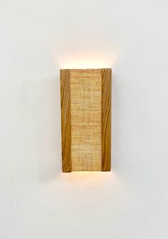 a light that is on the side of a wall with a wooden block attached to it