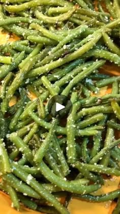 some green beans are sitting on a yellow plate