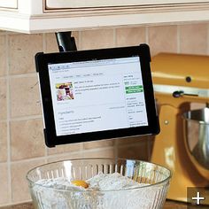 a tablet is sitting on the counter next to a mixing bowl with ice in it