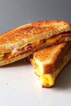 two grilled cheese sandwiches sitting on top of a white plate next to each other