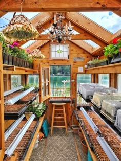 the inside of a greenhouse with lots of plants growing in pots and hanging from the ceiling