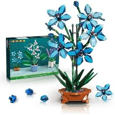 a blue flower arrangement in a pot next to a box