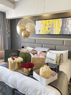 a bed with balloons, flowers and gifts on it