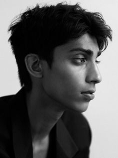 black and white photograph of a young man with short hair wearing a suit looking off to the side