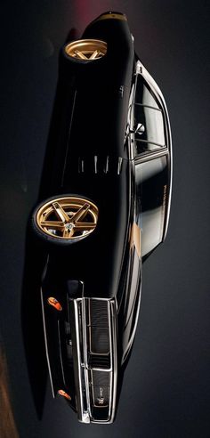 the top view of a black car with gold rims on it's hood