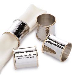 three silver napkin holders and two white napkins