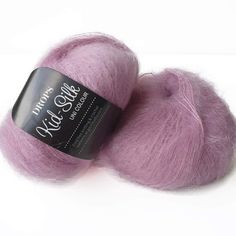 two skeins of purple wool on a white background with the label in front