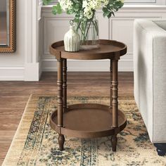 a living room with a couch, coffee table and vase on the rug in front of it