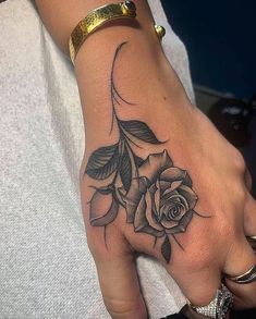 a woman's hand with a rose tattoo on it