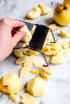 someone using a knife to cut up pieces of fruit on a marble counter top with peels