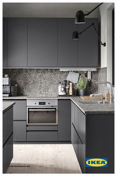 an image of a kitchen setting with grey cabinets and wood flooring on the walls