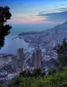 a view of a city and the ocean at dusk