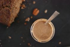 a cup of coffee sitting next to a piece of bread