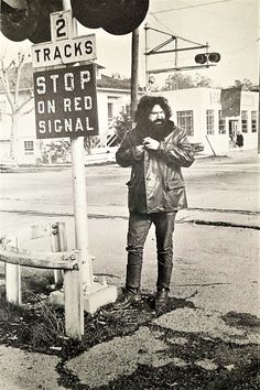 a man standing next to a stop sign