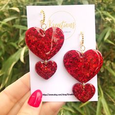 Beautiful striking oversized double red heart shaped hoop statement earrings made with resin, red colour pigment lots and lots of glitter! These elegantly designed heart earrings attract attention and add a unique piece to your jewellry collection. A perfect gift for your queen, girlfriend, woman, and girls, and of course not to forget for self gifting!  Attractive and eye catching, these sparkly dangling statement earrings catch the light beautifully. The hoops are The hoops are hyperallergenic and nickel free. It is possible to have the earrings med with silver details. Should you want that please let me know at check out. and nickel free. It is possible to have the earrings med with silver details. Should you want that please let me know at check out.  All earrings are handmade with lov Hearts Earrings, Red Heart Earrings, Earrings Double, Diy Resin Projects, Heart Shaped Earrings, Red Jewelry, Red Earrings, Red Colour, Valentines Jewelry