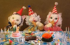 three stuffed animals sitting at a table with cakes and candles