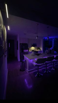 the kitchen is lit up with purple lights and features an island bench that sits in front of it