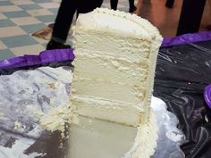 a piece of white cake sitting on top of a metal pan covered in frosting