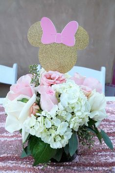 a vase filled with flowers and a minnie mouse topper