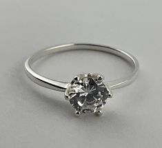 Silver ring with cubic zirconia solitaire stone. The ring has a prominent central stone secured with 6 claws, the stone measures 6mm in diameter. A simple and clean ring design. All mounted on a solid silver ring.  The ring is stamped internally with the makers mark 925 to mark it as silver, and the manufacturer stamp. Ring size uk P, us 7.5, eu 56 Stamp Ring, Clean Rings, Multi Stone Ring, Multi Stone, Makers Mark, Stone Rings, Ring Designs, Favorite Jewelry, Silver Ring