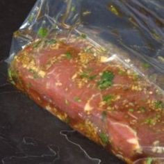 a piece of meat wrapped in plastic sitting on top of a counter