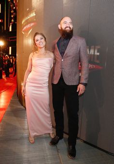 a man and woman standing next to each other on a red carpet at an event