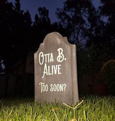 a grave marker with the words otta b alive too soon written on it at night