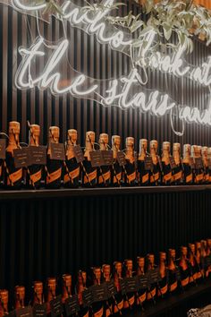 rows of wine bottles are lined up on the wall in front of a sign that says,