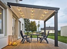 an outdoor deck with chairs and lights on it