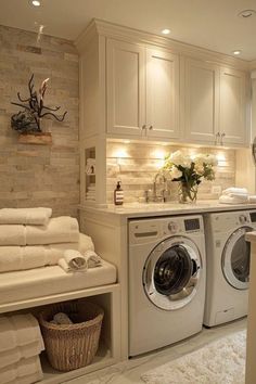 a washer and dryer in a room with white towels on the counter top