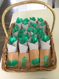 a basket filled with green and silver plastic utensils on top of a table