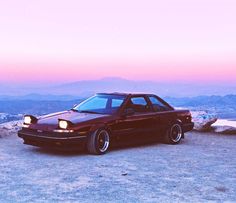 a red car parked on top of a mountain