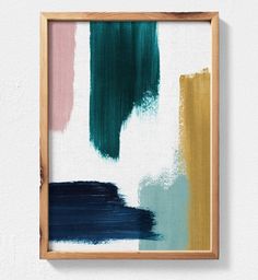 a painting hanging on the wall with a wooden frame over it that has been painted in different shades of green, pink and blue