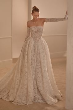 a woman in a wedding dress leaning against a wall