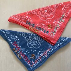 two bandanas are sitting on top of each other, one is red and the other is blue