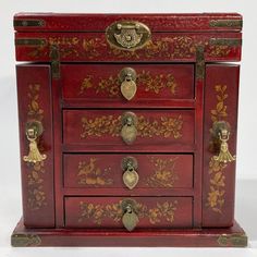 a red wooden chest with gold decorations on the front and sides, sitting against a white background