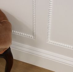 a brown chair sitting in front of a white wall