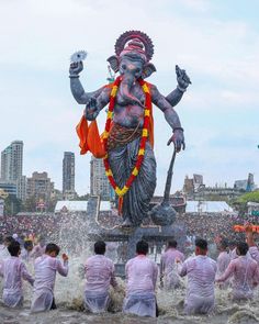 a group of men standing around a statue in the water