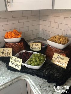 a table topped with bowls filled with different types of grapes next to plates of cheese and crackers