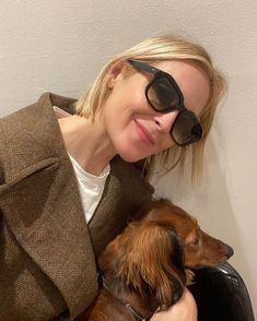 a woman wearing sunglasses and holding a dog