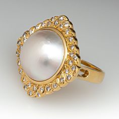 This fabulous vintage cocktail ring is centered with one (1), bezel set, round maybe' pearl and is bordered with thirty-six (36), bead set, round brilliant cut diamond. The ring measures 24.9mm at the top, rises 11.0mm above the finger, tapering to 3.4mm wide and 1.1mm thick at the base of the shank. The ring is currently size 6.5. Vintage Cocktail Ring, Diamond Cocktail Ring, Mabe Pearl, Diamond Cocktail Rings, Bead Set, Vintage Cocktail, Pearl Diamond, October Birth Stone, Round Brilliant Cut Diamond