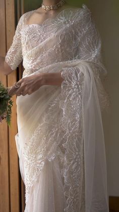 a woman in a white dress holding flowers