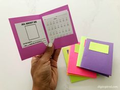 a person holding an open book with sticky notes attached to it and some post - it notes in front of them