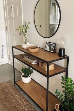 a mirror and some plants on a shelf in front of a door with a potted plant