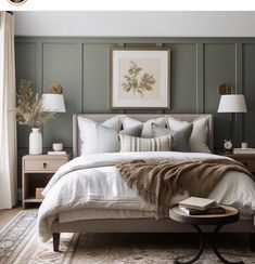 a large bed sitting next to two lamps on top of a wooden table in a bedroom