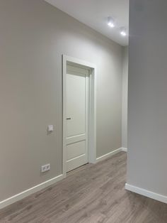 an empty room with white walls and wood floors is pictured in this image from the doorway