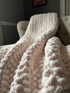 a white blanket sitting on top of a couch