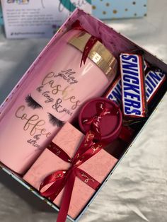 a pink box with some chocolates in it and an empty bottle next to it